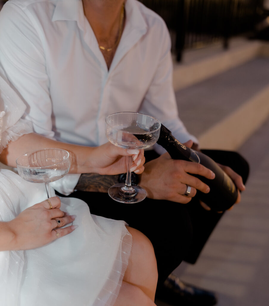 Champagne glasses in downtown engagement photos.