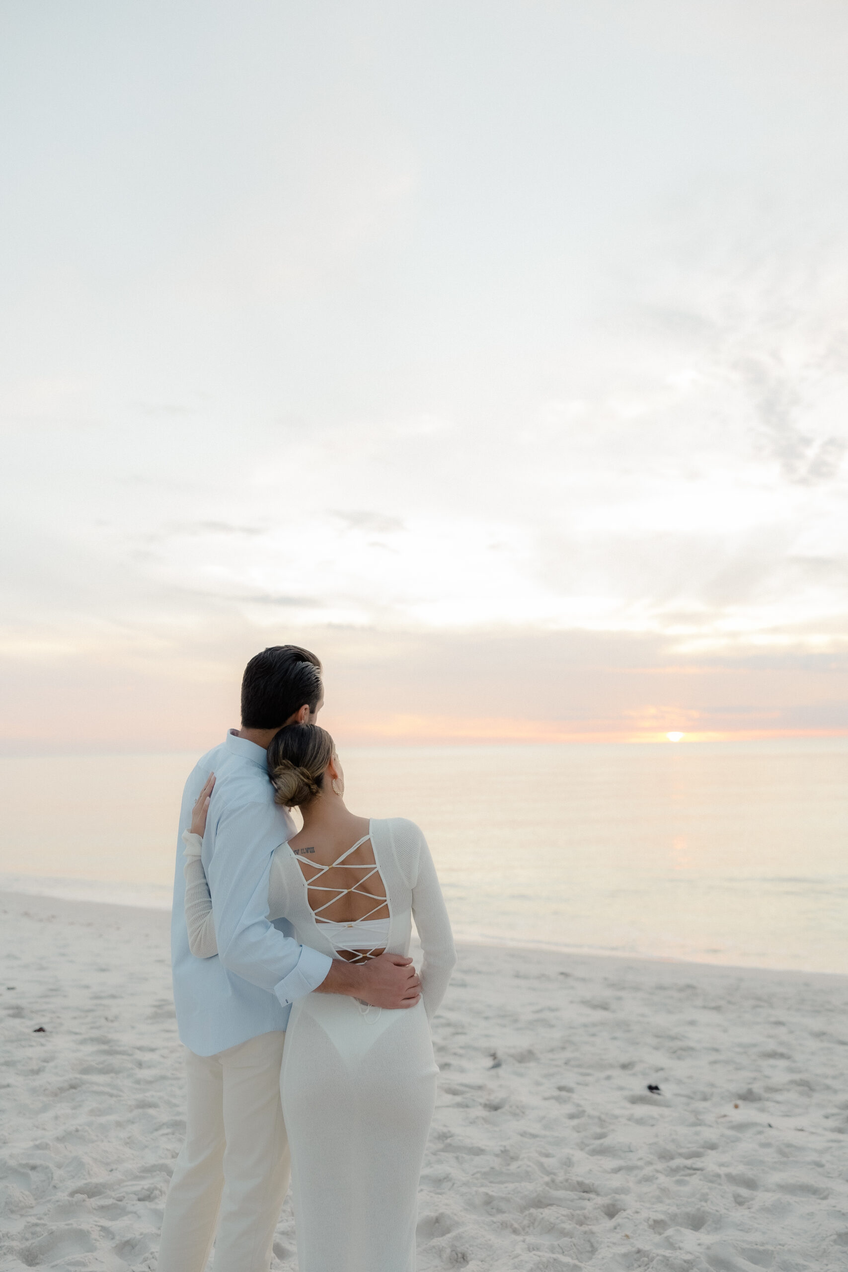 A romantic silhouette of a couple on Naples Beach, captured by Maddie Briggs, a talented Naples Florida photographer, as the sun dips below the horizon, creating a dreamy, creamy sunset backdrop.