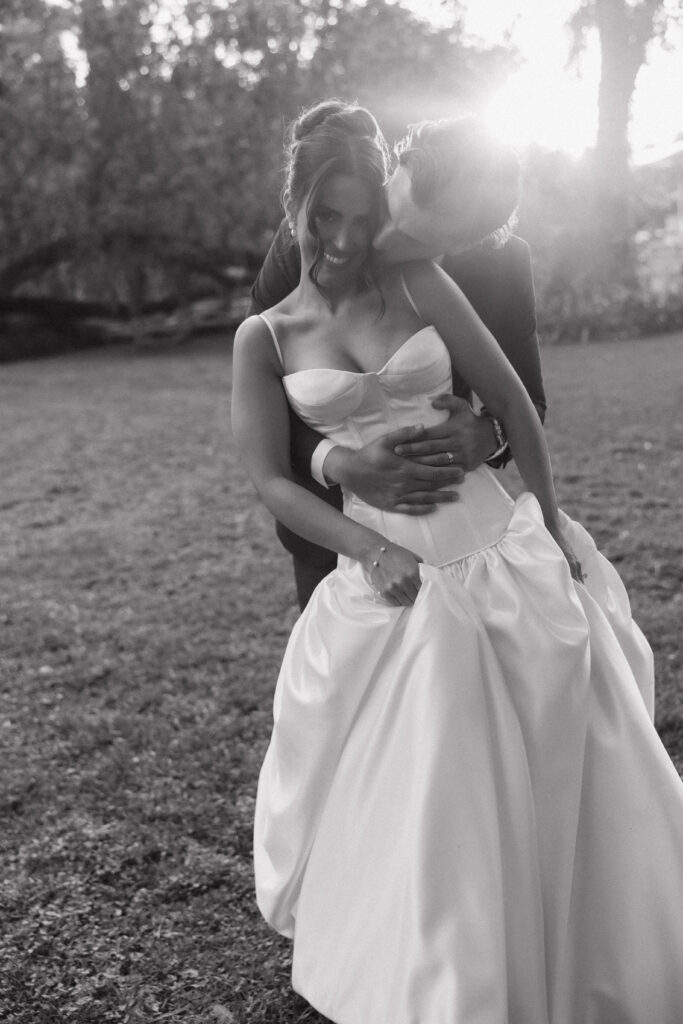 Bride and groom walking hand in hand through oak trees at sunset in Florida